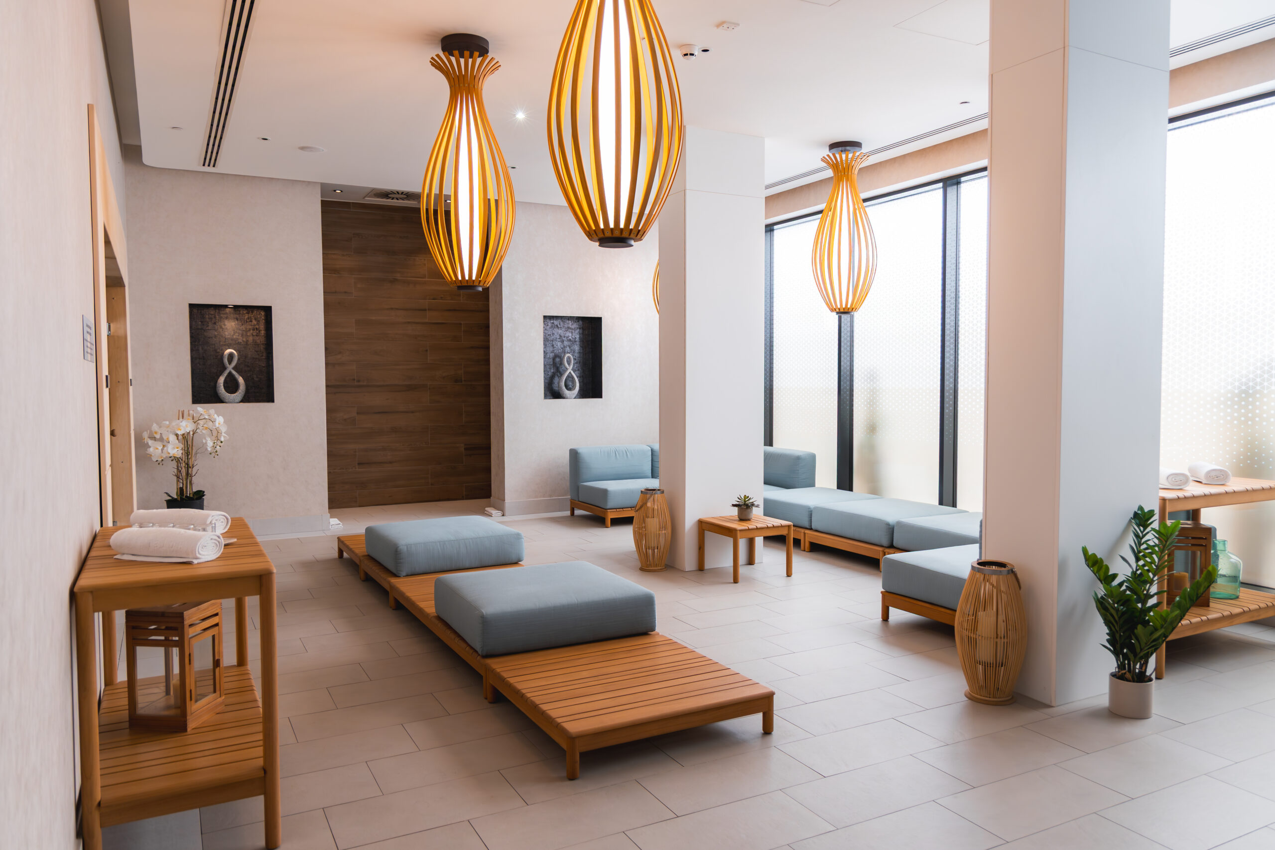 Modern hotel wellness lounge with natural wood finishes, soft seating, and calming design elements, highlighting construction and renovation that support wellness tourism.